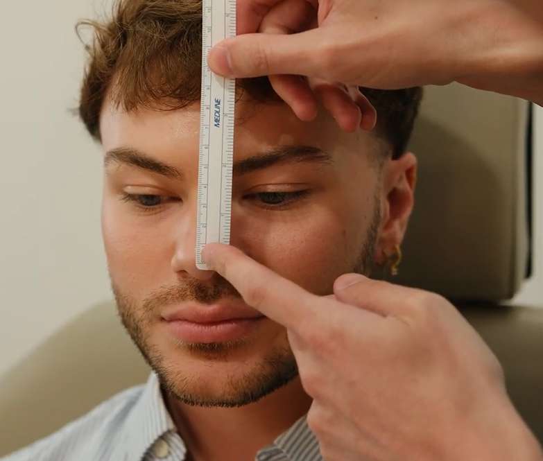 Facial plastic surgeon consulting with a patient during an in-office evaluation